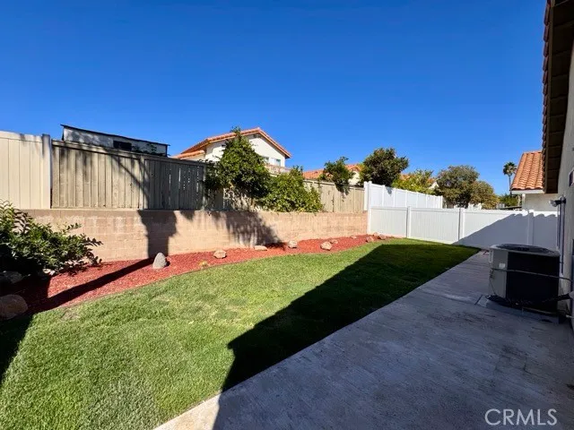 a view of a white house with a big yard and potted plants