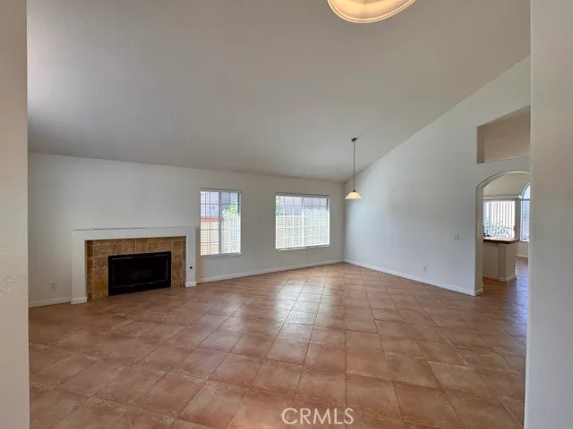 an empty room with windows and fireplace
