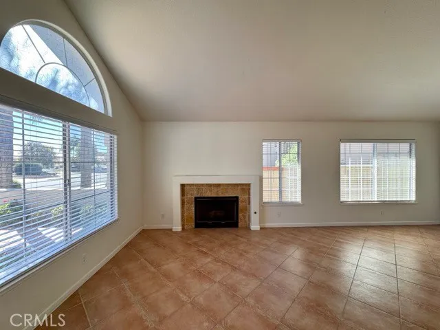 an empty room with fireplace and windows