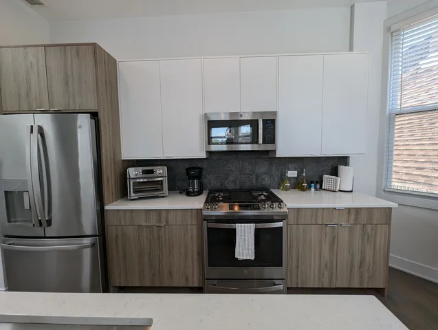 a kitchen with stainless steel appliances wooden cabinets and a stove