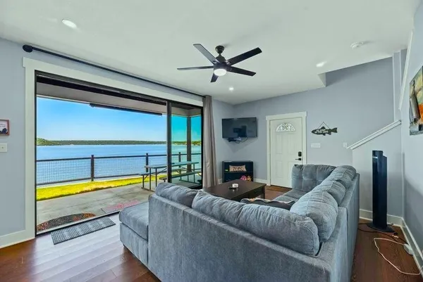 a living room with furniture kitchen view and a wooden floor
