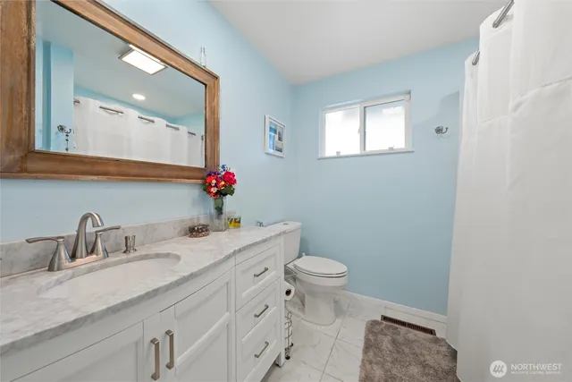 a bathroom with a granite countertop sink and a mirror