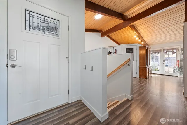 a view of a hallway with wooden floor and staircase