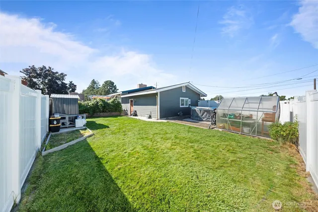 a backyard of a house with table and chairs