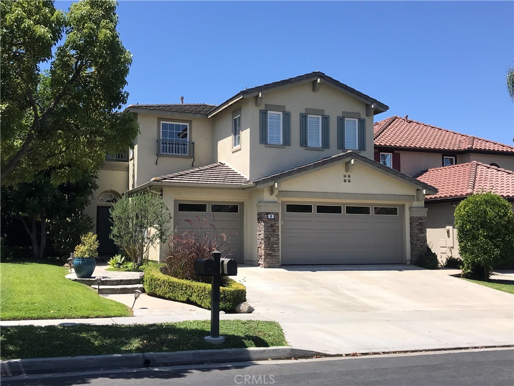 4 Whispering Pine Irvine, CA 92620 - Photo 1 of 3 a front view of a house with a yard and garage