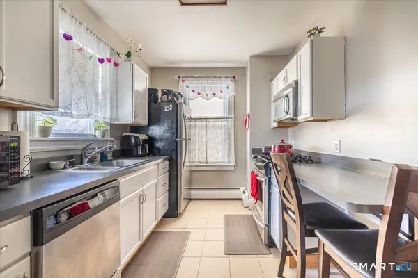 a kitchen with a sink appliances cabinets and a window