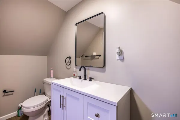 a bathroom with a sink vanity mirror and toilet