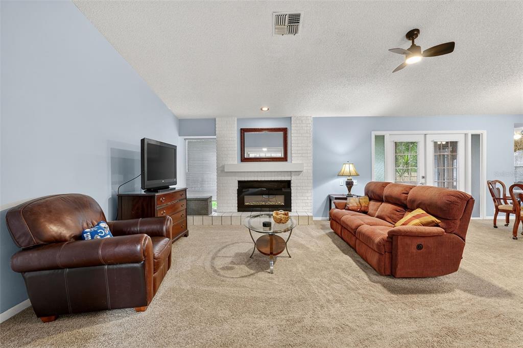 3602 Player Drive New Port Richey, FL 34655 - Photo 18 of 42 a living room with furniture a fireplace and a flat screen tv