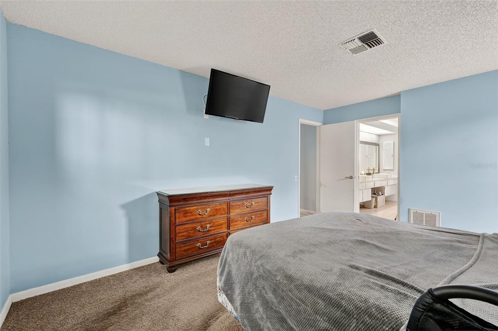 3602 Player Drive New Port Richey, FL 34655 - Photo 24 of 42 a bedroom with a bed and a flat screen tv