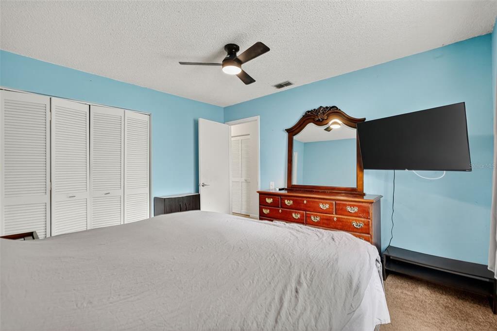 3602 Player Drive New Port Richey, FL 34655 - Photo 28 of 42 a bedroom with a bed and a flat tv screen on dresser