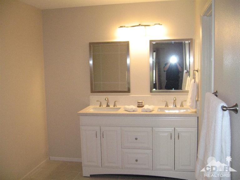 200 East Racquet Club Road, Unit 52 Palm Springs, CA 92262 - Photo 13 of 28 a bathroom with a double vanity sink and mirror