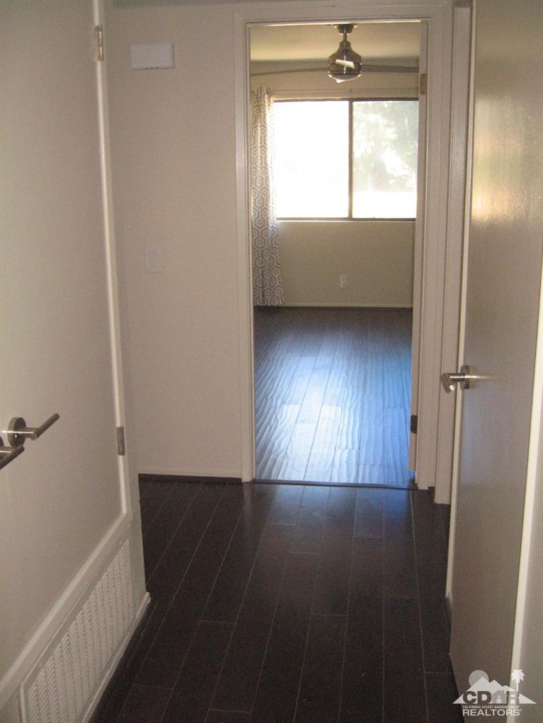 200 East Racquet Club Road, Unit 52 Palm Springs, CA 92262 - Photo 14 of 28 a view of an empty room with wooden floor and a window
