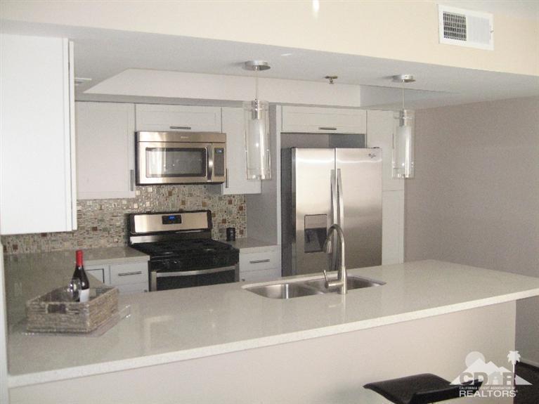 200 East Racquet Club Road, Unit 52 Palm Springs, CA 92262 - Photo 2 of 28 a kitchen with a refrigerator a stove and a sink