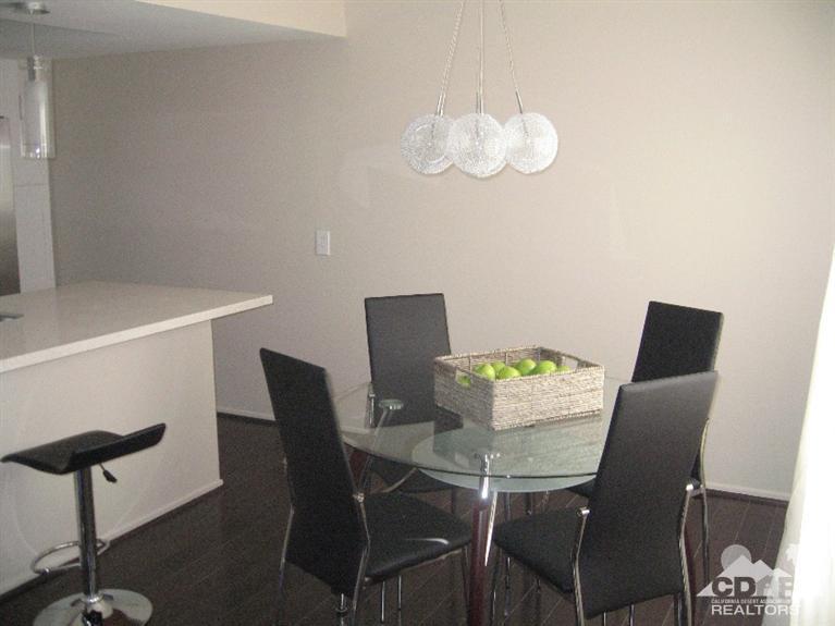200 East Racquet Club Road, Unit 52 Palm Springs, CA 92262 - Photo 3 of 28 a view of a dining room with furniture and wooden floor