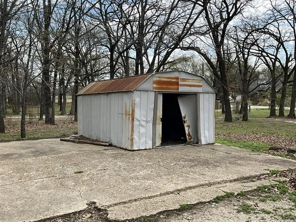 a view of a house with a yard and large tree