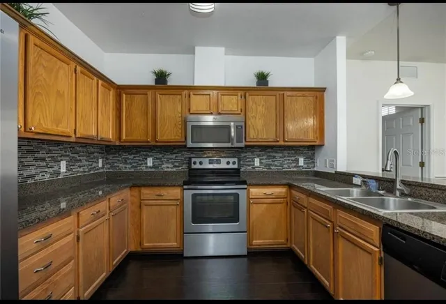 a kitchen with stainless steel appliances granite countertop a sink stove and cabinets