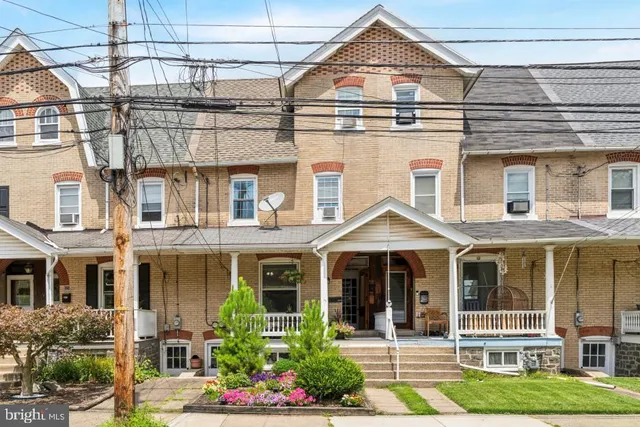 front view of a brick house with a yard