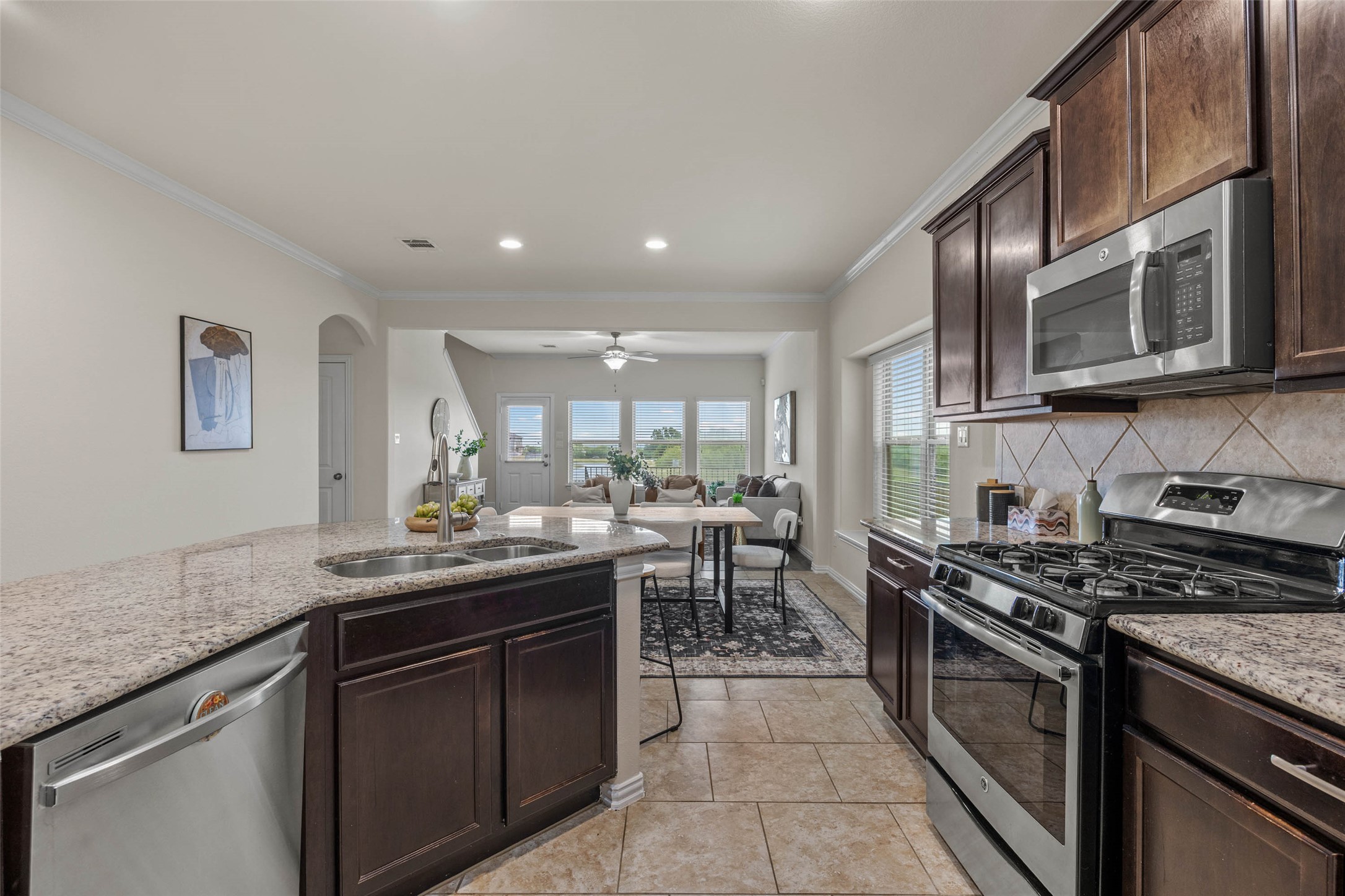 536 Rancho Verde Drive Leander, TX 78641 - Photo 4 of 37 a kitchen with stainless steel appliances granite countertop a stove a sink and a microwave