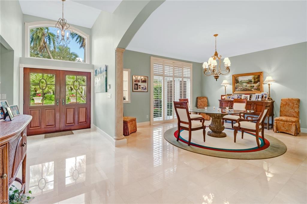 4556 Silver Fox Drive Naples, FL 34119 - Photo 7 of 22 a view of a dining room with furniture a chandelier and large windows