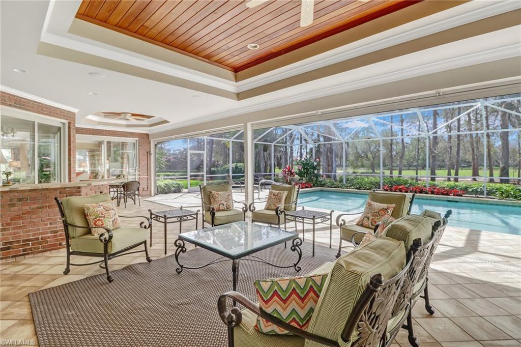4556 Silver Fox Drive Naples, FL 34119 - Photo 9 of 22 a living room with patio furniture and a floor to ceiling window
