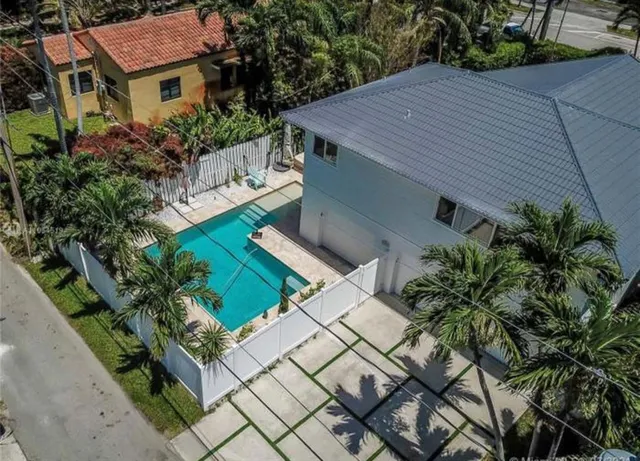 a aerial view of a house with a yard and potted plants