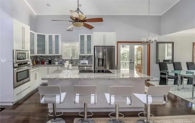a kitchen with white cabinets a sink and appliances