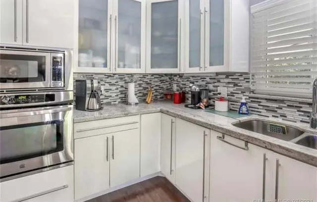 a living room with furniture kitchen view and a chandelier