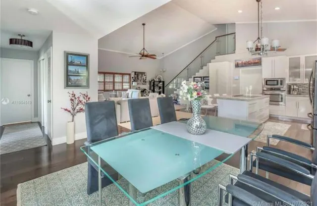 a bedroom with a bed a dresser and wooden floor