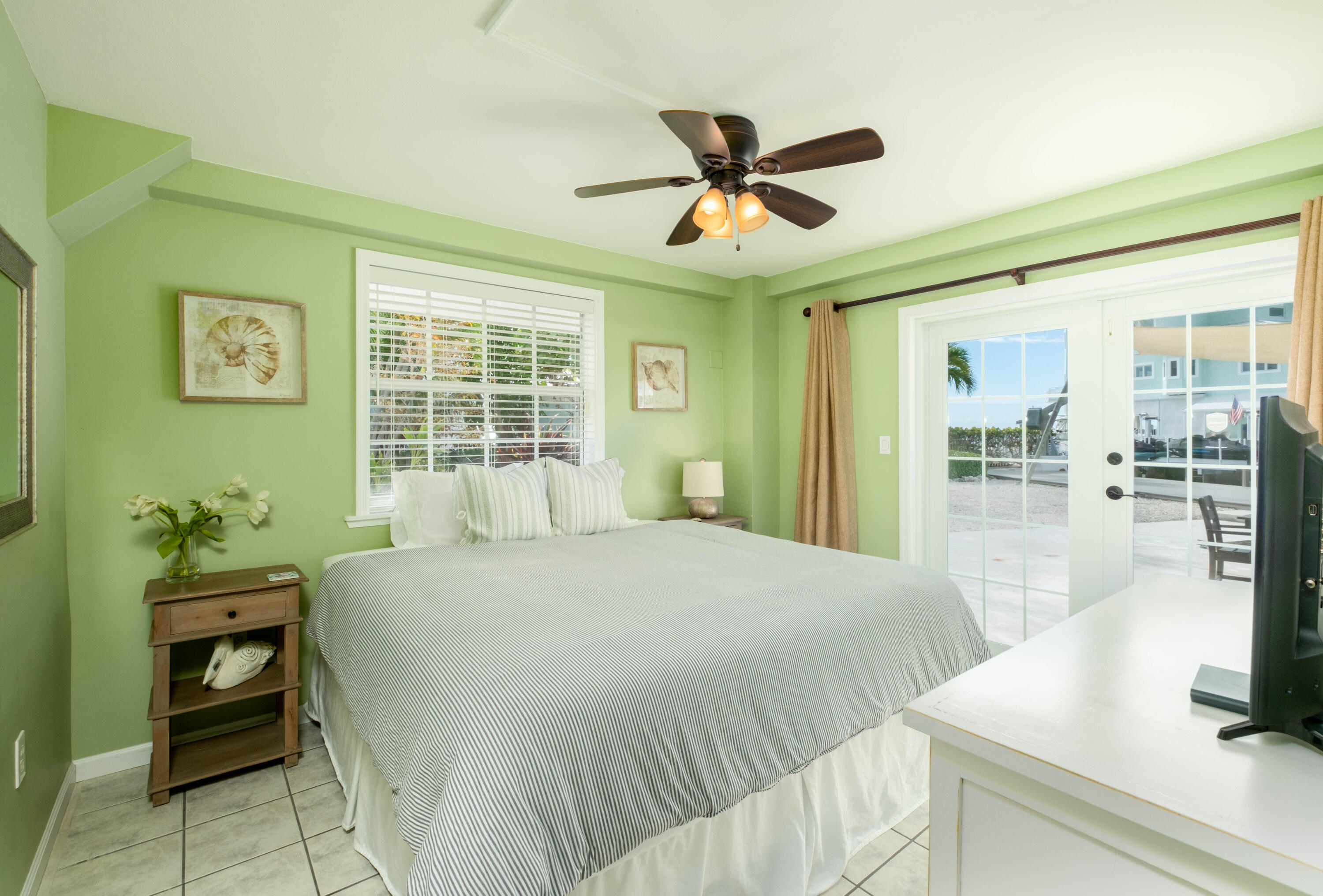 1202 Mockingbird Road Key Largo, FL 33037 - Photo 19 of 38 a bedroom with a bed and large windows