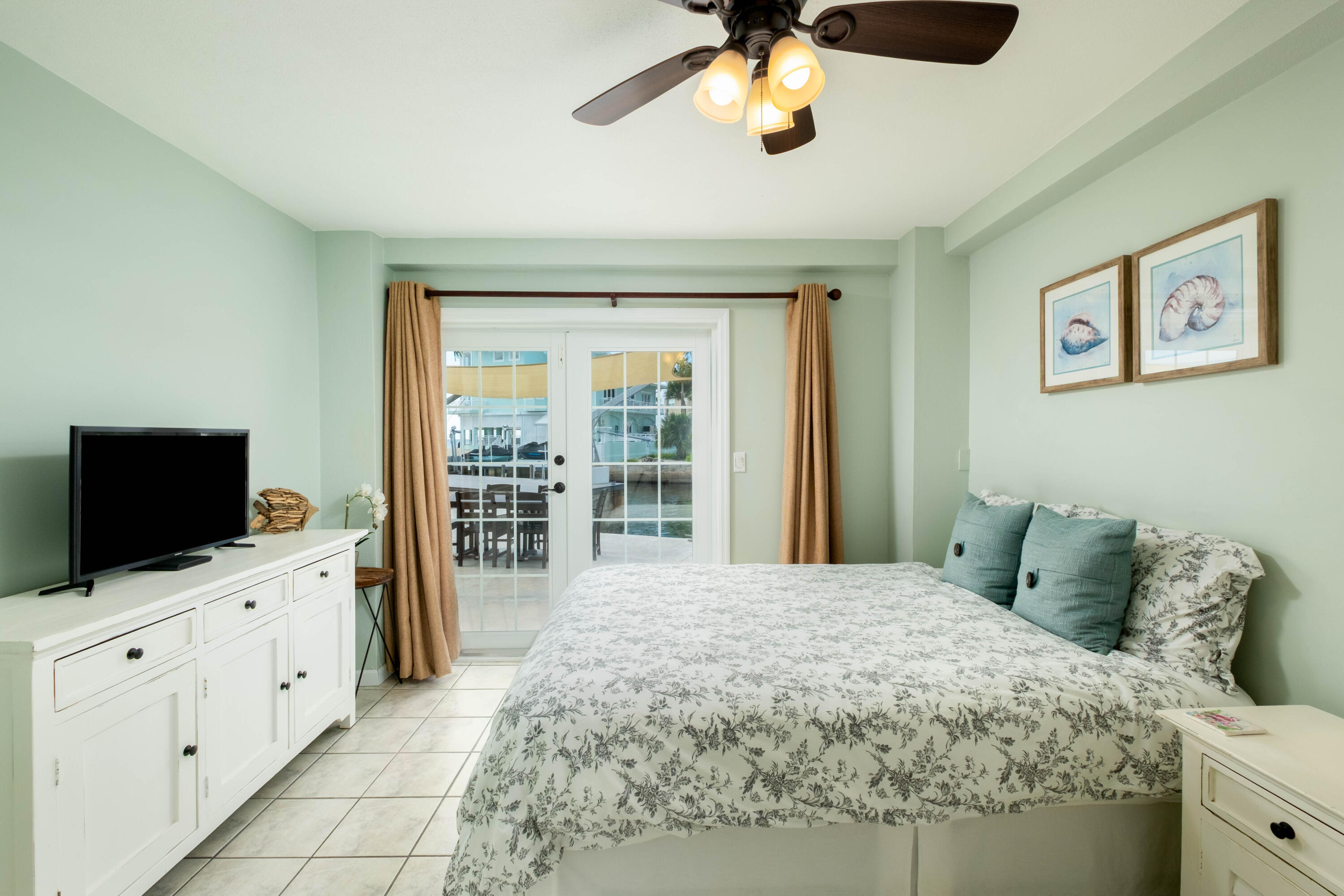 1202 Mockingbird Road Key Largo, FL 33037 - Photo 20 of 38 a bedroom with a bed and a flat screen tv