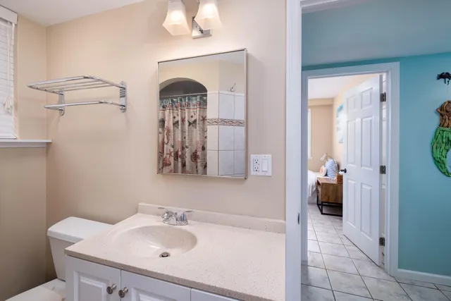 a bathroom with a granite countertop sink a mirror and shower