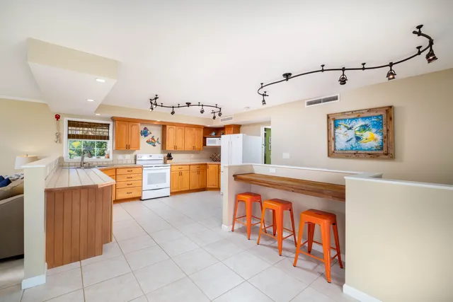 a kitchen with granite countertop a refrigerator and a sink