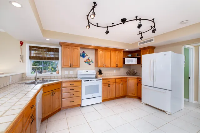 a kitchen with granite countertop cabinets stainless steel appliances a sink and a window