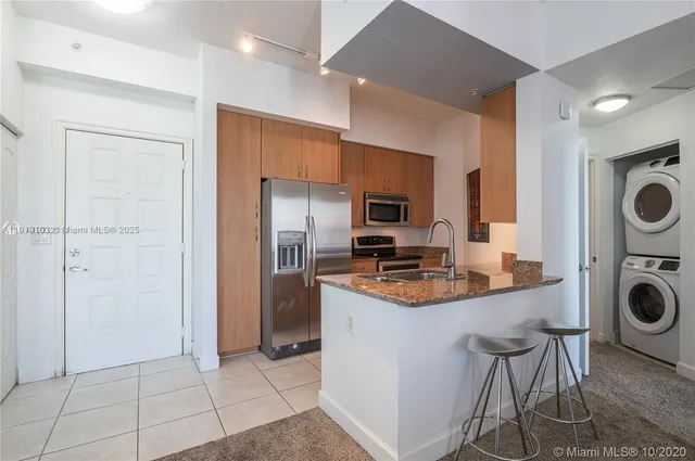 a kitchen with stainless steel appliances granite countertop a stove a refrigerator and a sink