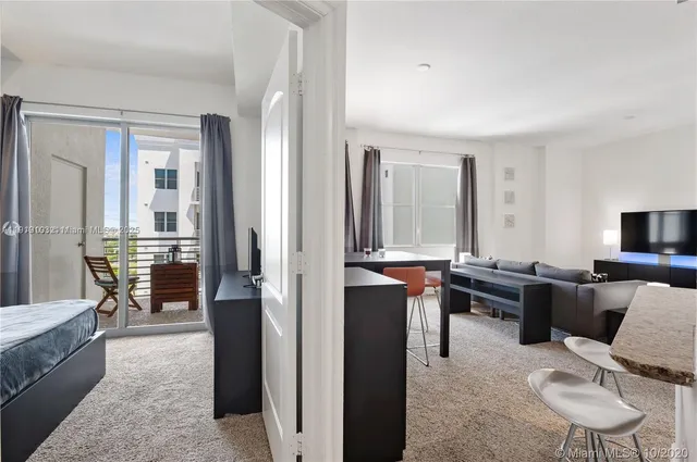 a living room with furniture a large window and a flat screen tv