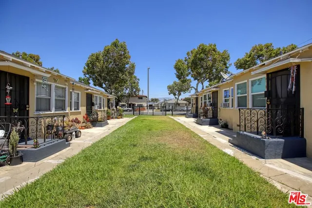 a view of a house with backyard and sitting area