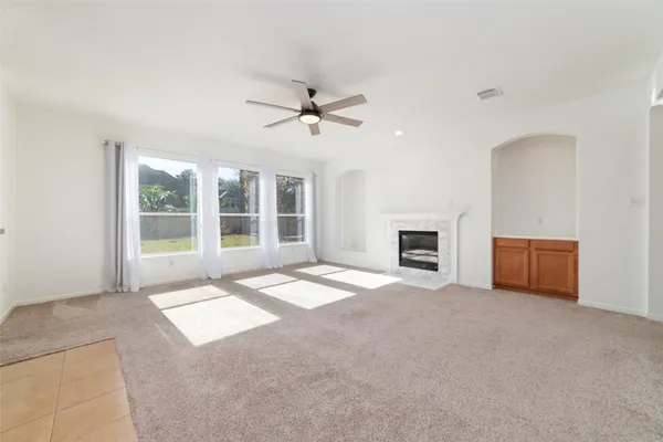 a view of an empty room with a fireplace and a window