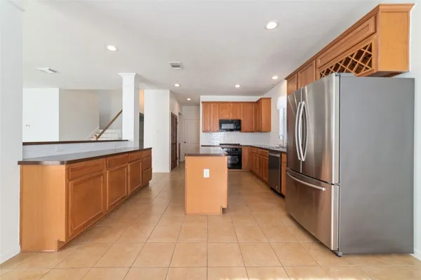 a open kitchen with stainless steel appliances granite countertop a refrigerator and a sink