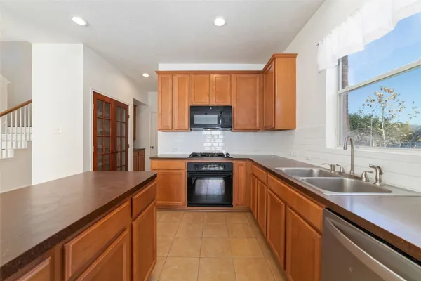a kitchen with stainless steel appliances granite countertop a sink stove and cabinets