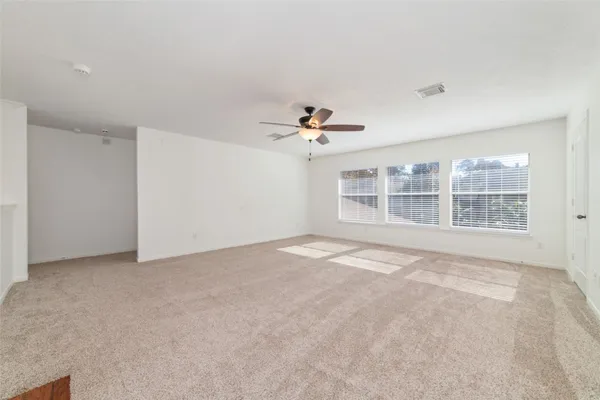 a view of a livingroom with a chandelier fan and refrigerator