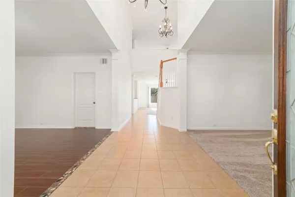 a view of a hallway with a dining table and a chandelier