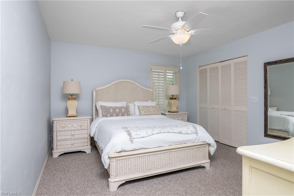 105 Georgetown Boulevard, Unit 105 Naples, FL 34112 - Photo 13 of 28 a bedroom with a bed and a chandelier