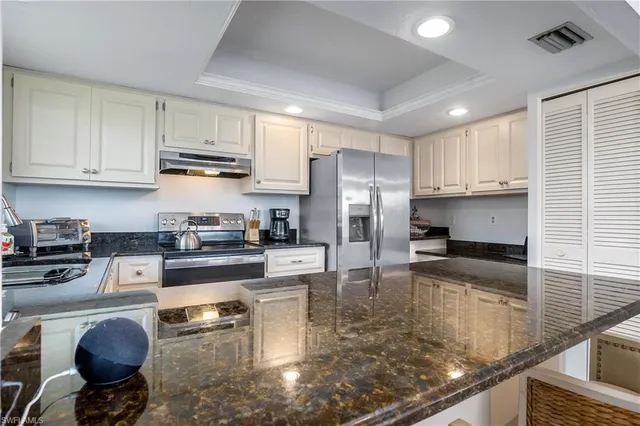 a kitchen with stainless steel appliances granite countertop a sink refrigerator stove and cabinets