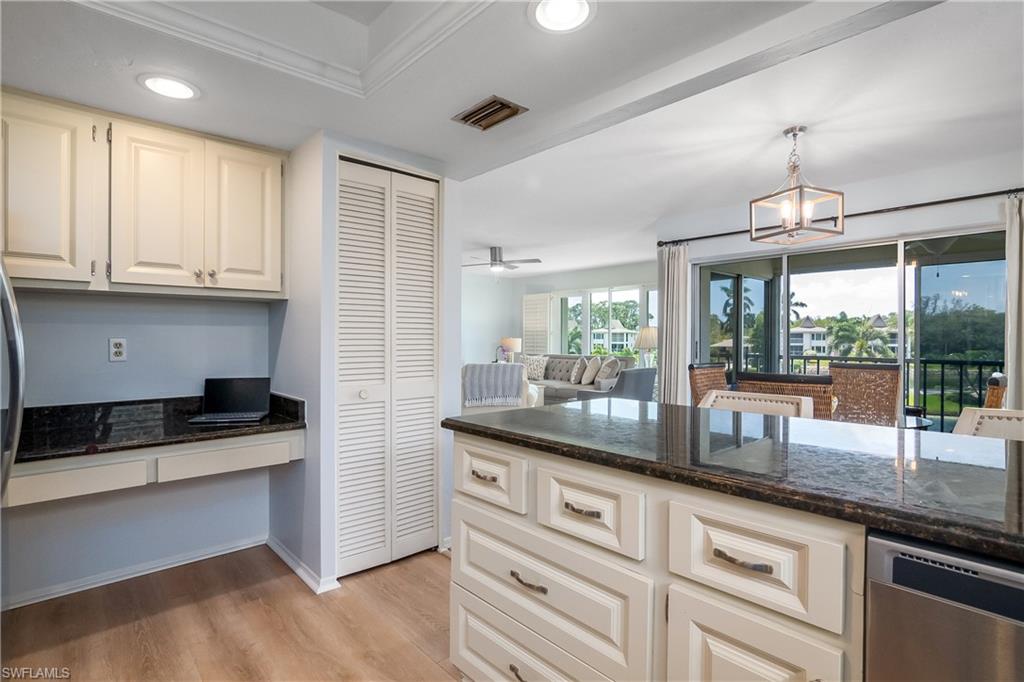 105 Georgetown Boulevard, Unit 105 Naples, FL 34112 - Photo 6 of 28 a kitchen with granite countertop kitchen island white cabinets and stainless steel appliances