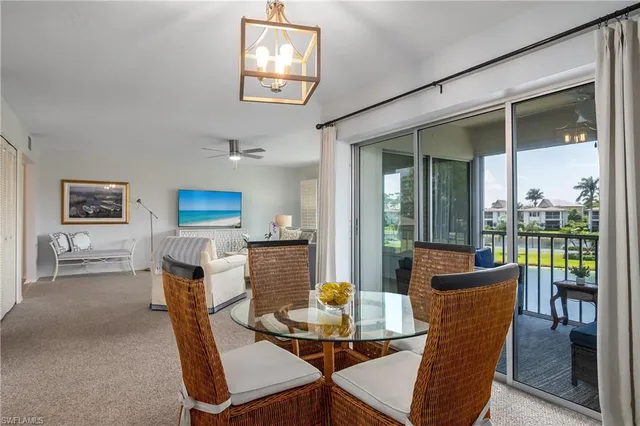 a dining room with furniture and a floor to ceiling window
