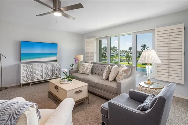 a living room with furniture a rug and a window