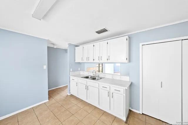 a kitchen with a sink cabinets and wooden floor