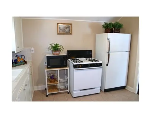 a kitchen with a refrigerator and a stove top oven