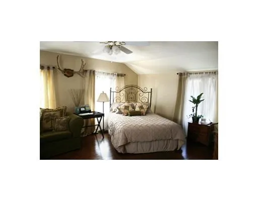 a bedroom with a bed window and a mirror