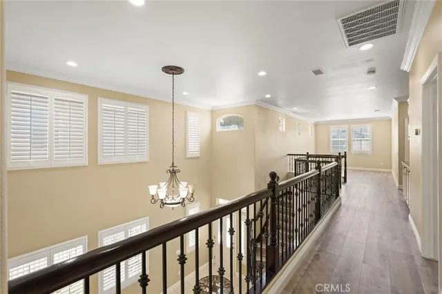 a view of a hallway with wooden floor and windows